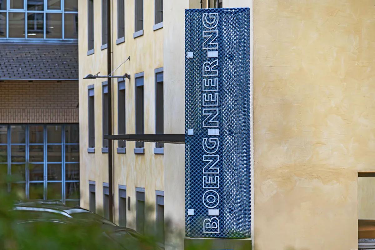 Bioengineering wurde 1972 in Uster gegründet, seit 1978 ist das Unternehmen in Wald ansässig. Der Hauptsitz der Bioengineering AG in Wald. Man sieht eine gelbe Fassade und ein blaues, transparentes Firmenschild.